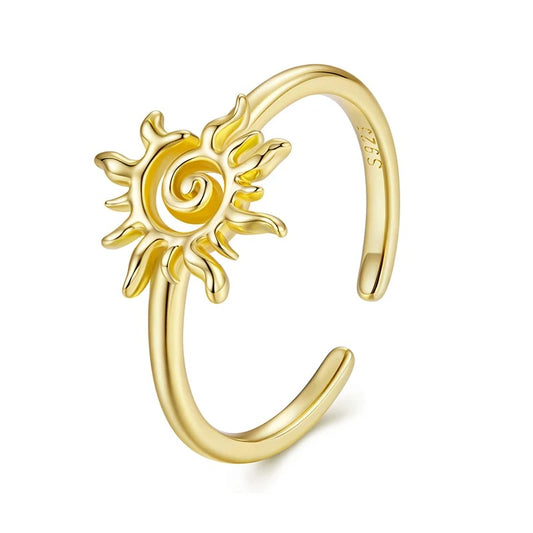 Gold ring with sun design on a white background