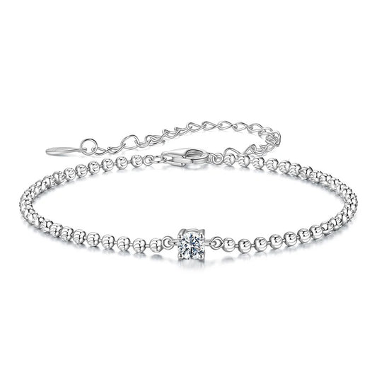 Silver bracelet with a small cross charm on a white background